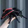 A small stuffed cinnabar moth with blue wings