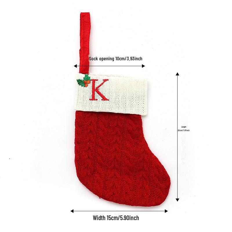 Weihnachtsdekorationen: Rote gestrickte Kinderstrümpfe mit gestickten Buchstaben