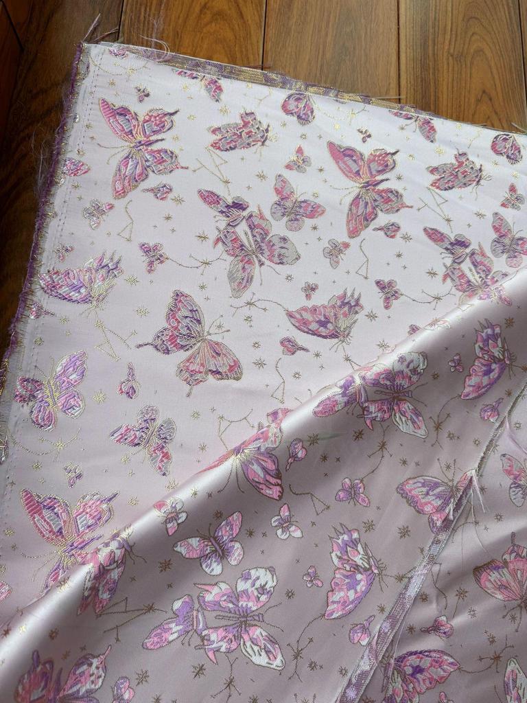 Ethnischer Jacquardstoff für Damen- und Kinderbekleidung in Rosa, Lila, Rot und Gold.