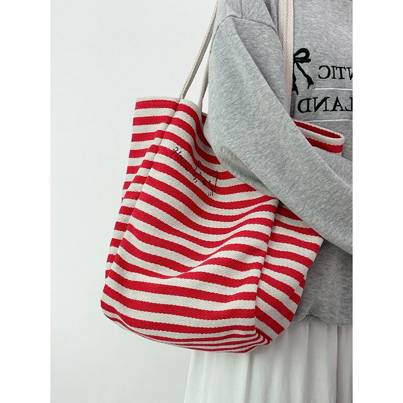 Large capacity striped canvas bag women's 2025 new niche embroidery lazy wind commuter portable shoulder tote bag