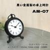 The BESTIME AM-07 is a small, exquisitely crafted black metal desk clock with a white dial and easy-to-read black numerals. It measures 14.9cm high,