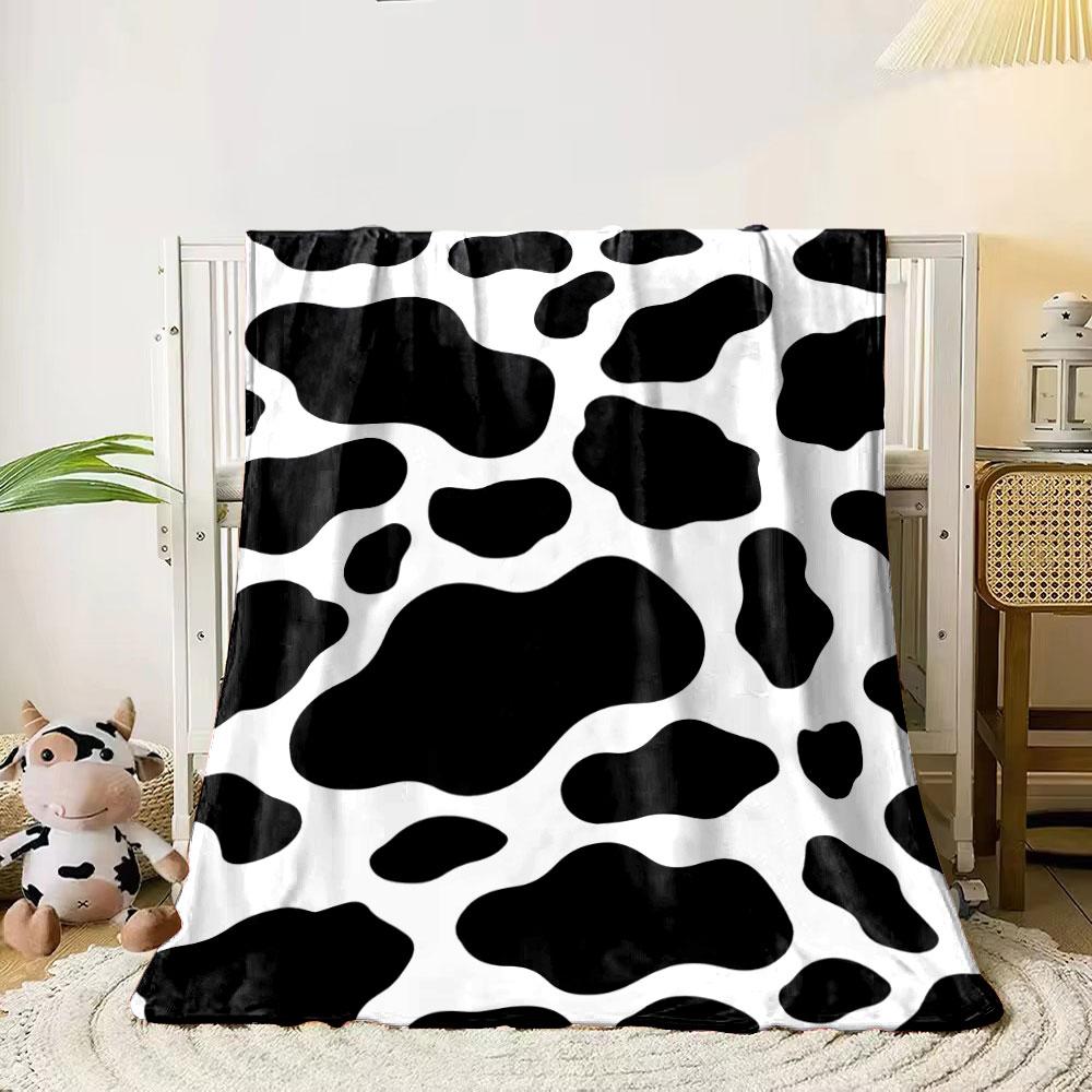

Black irregular spots on a white background resembling a cow print. for all seasons blanket lunch break throw gift 80cm x 120cm