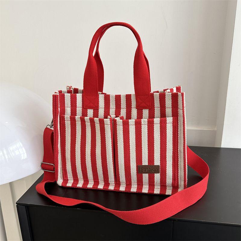 

Large capacity bag 2025 new women s bag popular striped canvas bag messenger bag fashion commuter portable tote bag красный