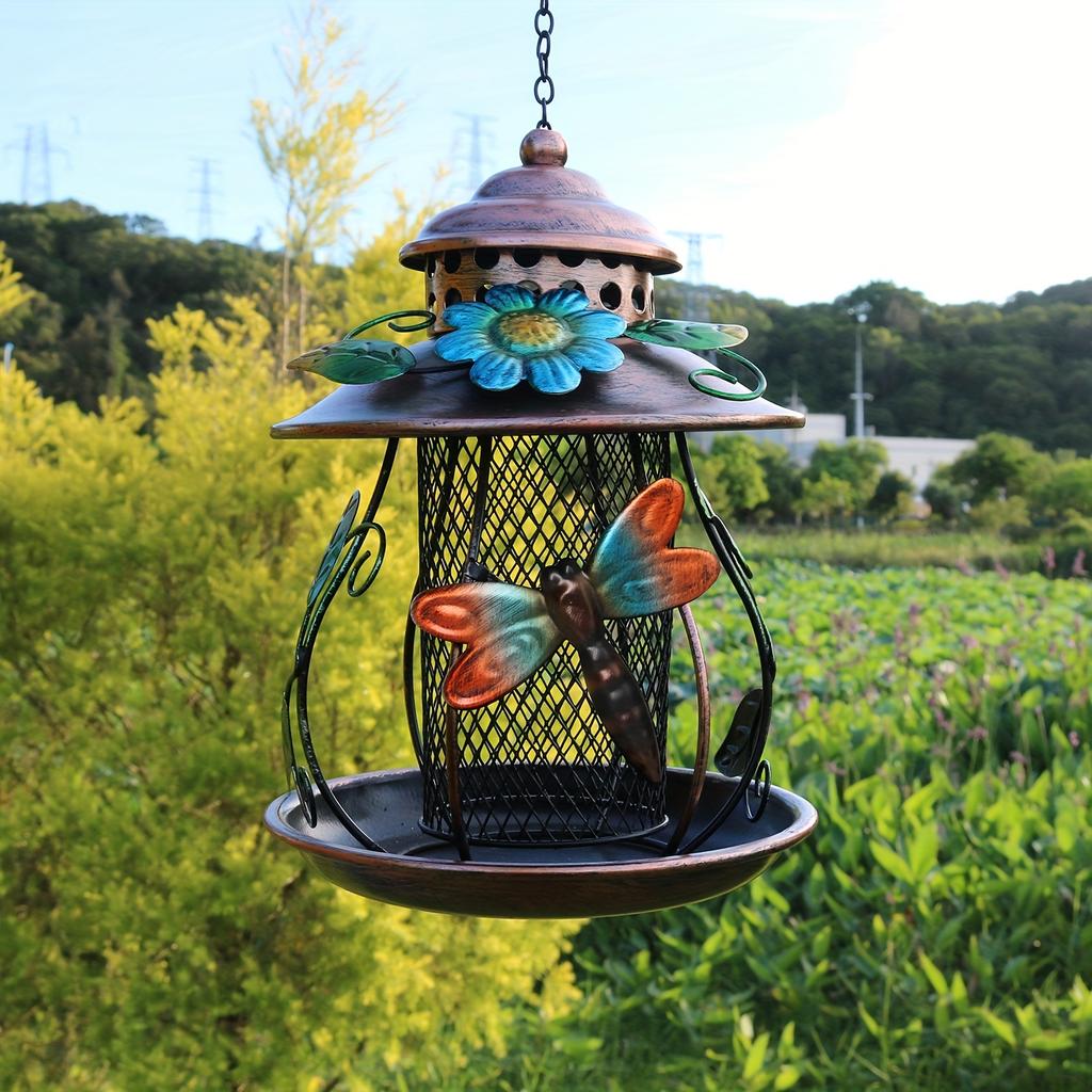 An outdoor hanging bird feeder with hooks and iron mesh, featuring decorative dragonfly and flower patterns, suitable for use in gardens or
