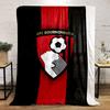 A shield with a soccer player heading a ball and vertical red stripes. for all seasons blanket lunch break throw gift