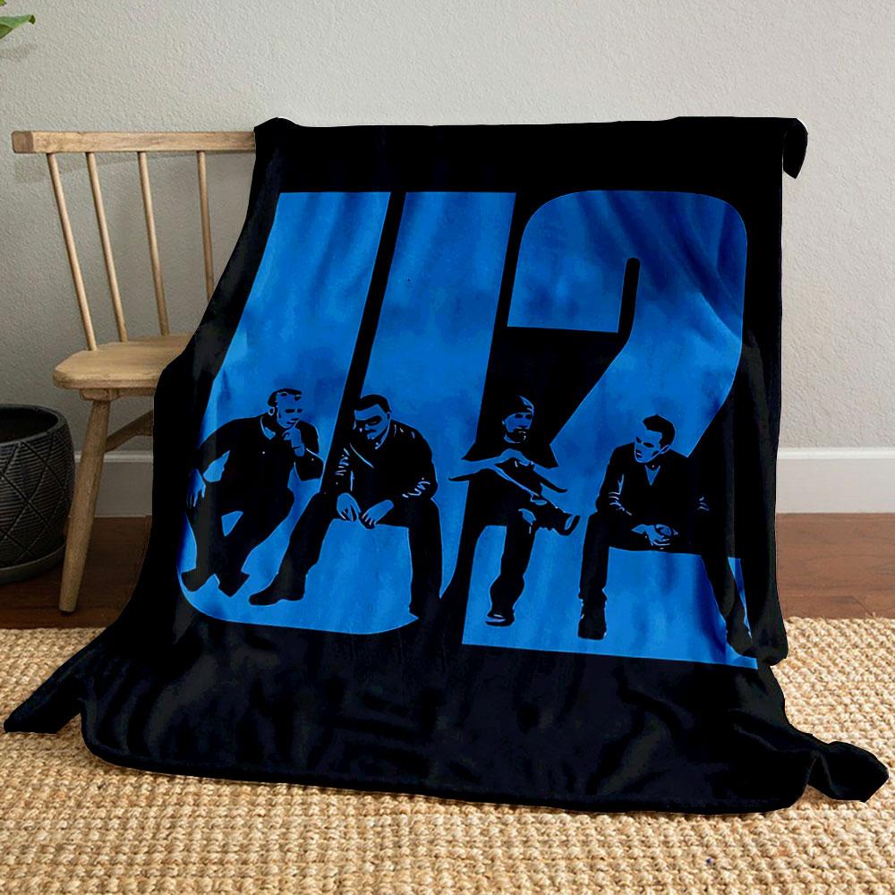 Bold blue "U2" text integrates silhouettes of seated figures in black. for all seasons blanket lunch break throw gift