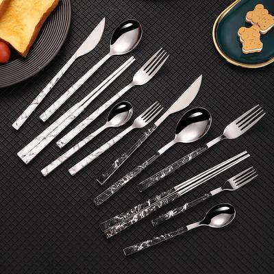 Koreanisches Besteckset im Retro-Stil: Messer, Gabel, Löffel und Essstäbchen mit Holzmaserung und Griff im Marmormuster.