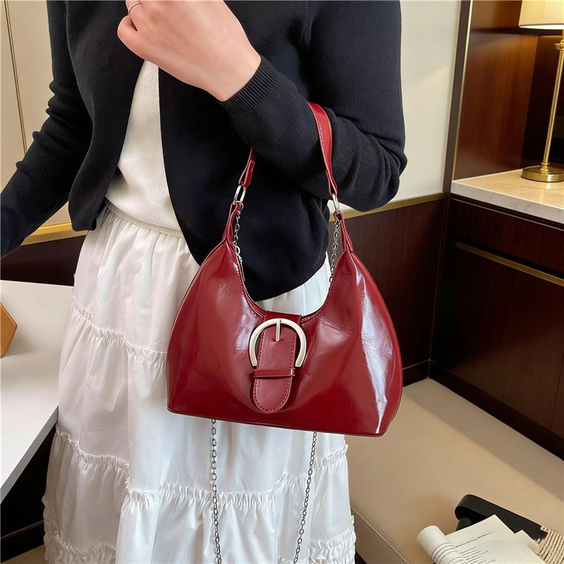 Solid color crescent-shaped hobo bag with metal D-ring embellishment, elegant underarm bag, versatile women's handbag for dates and everyday wear.