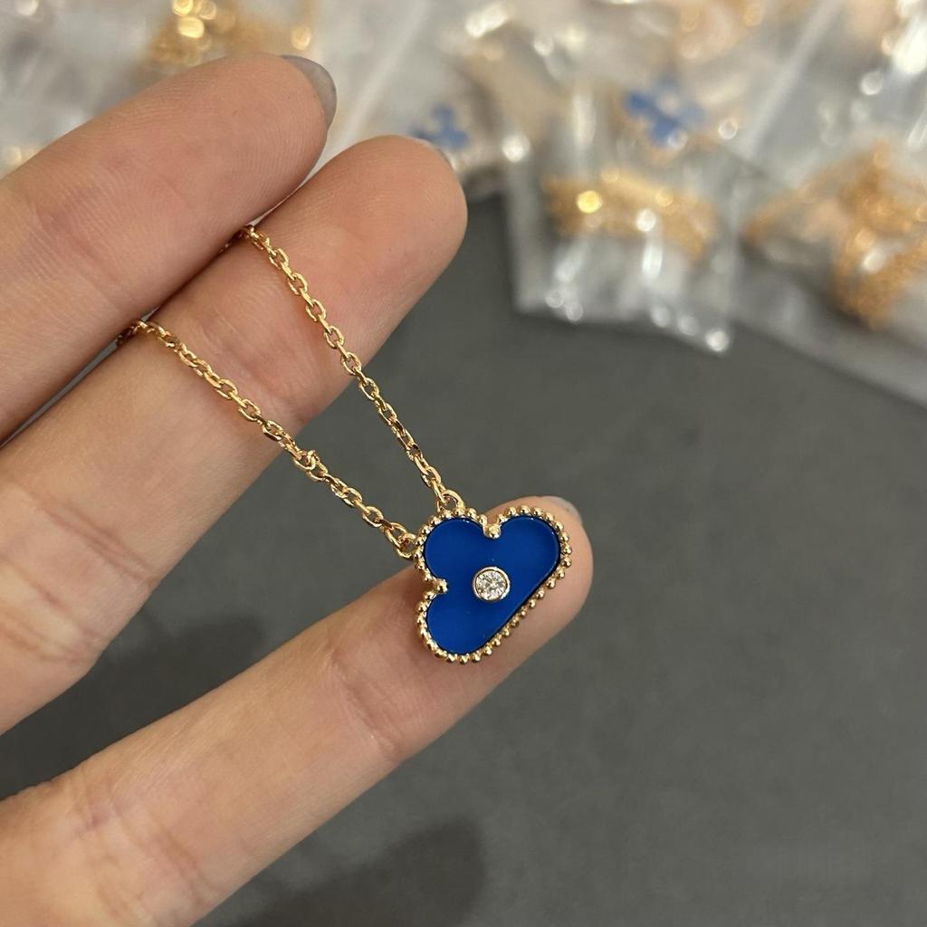 Náhrdelník Van Cleef se čtyřlístkem: Zlatý přívěsek pro ženy s pětilistým designem, bílou perletí, červeným achátem a diamantem.