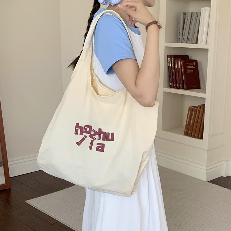 

Simple literary and large-capacity canvas bag women s 2025 new lazy style letter printing shoulder tote bag бежевый