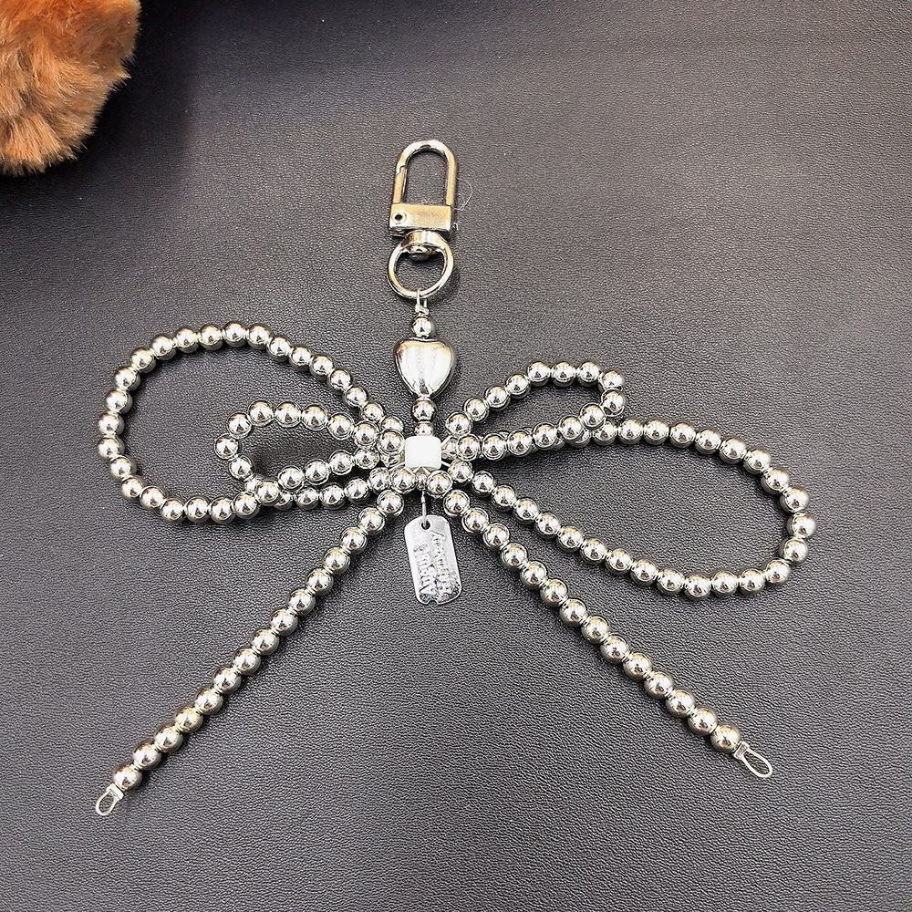Fashionable Korean-inspired blogger-style large pearl bow mobile phone pendant key chain with heart design.