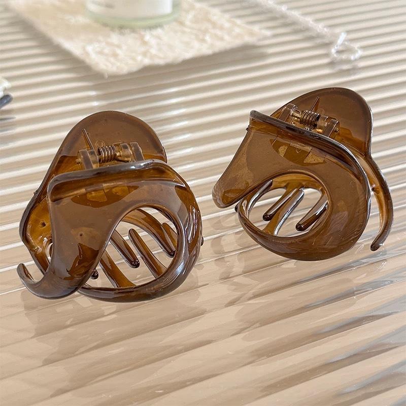Fermagli per Capelli da Donna dall'Aspetto Sofisticato, con uno Chignon Basso con Capelli Spaziati sul Retro, e un Accessorio per Capelli a Forma di Squalo.