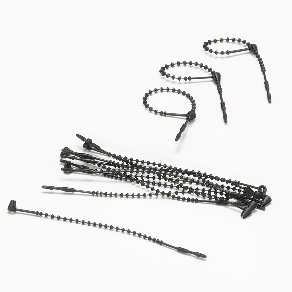 Schwarzes handgenähtes Fadenetikett mit einem Perlengarn, einer Gumminadel und Fadenetikett