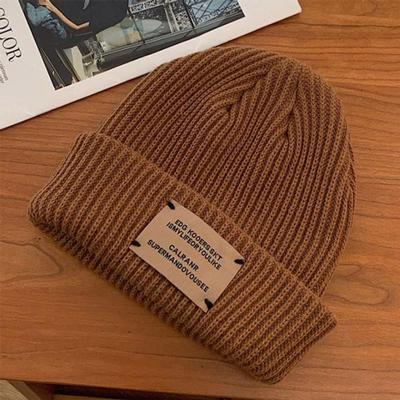 Gestrickte lange braune Mütze mit gesticktem Aufnäher
