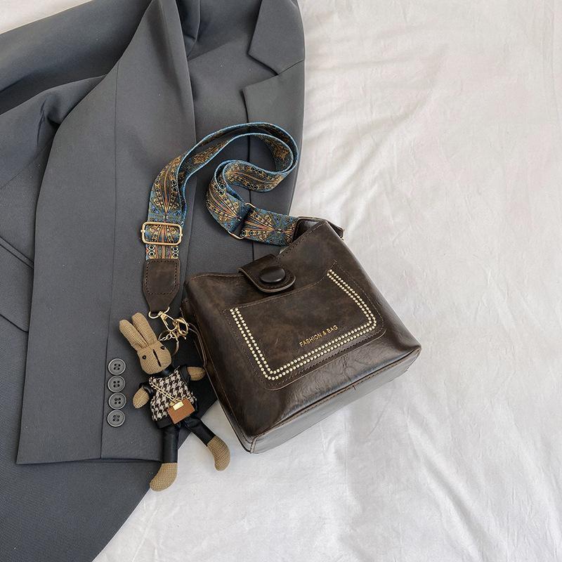 

Весняна нова мода 2024 року, повсякденна сумка-відро, ніша, корейська версія, ретро, ​​суцільна кольорова сумка для приміських поїздок із широким плечовим ременем, жіноча сумка Without pendant