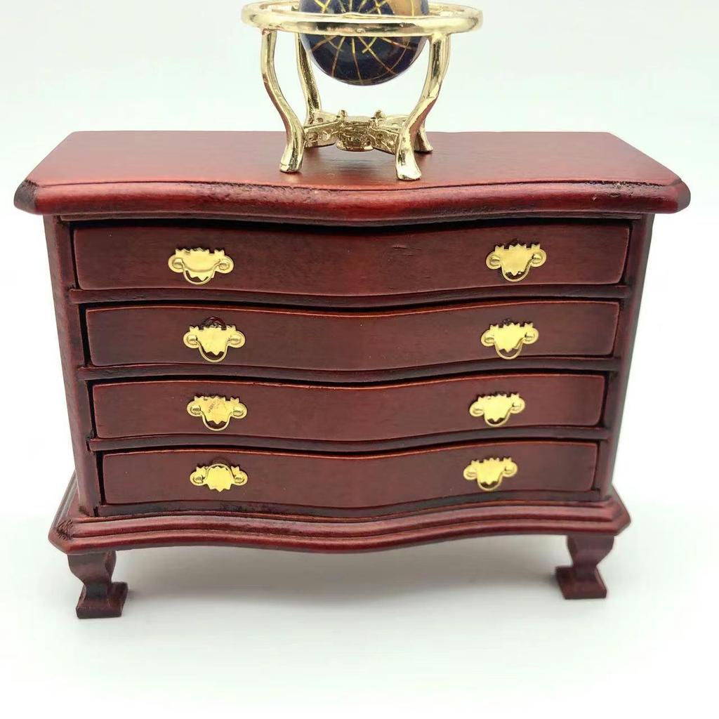 Miniatur-Puppenhaus-Schrank mit vier Schubladen, mit Tonlebensmitteln und Holzmöbelzubehör.