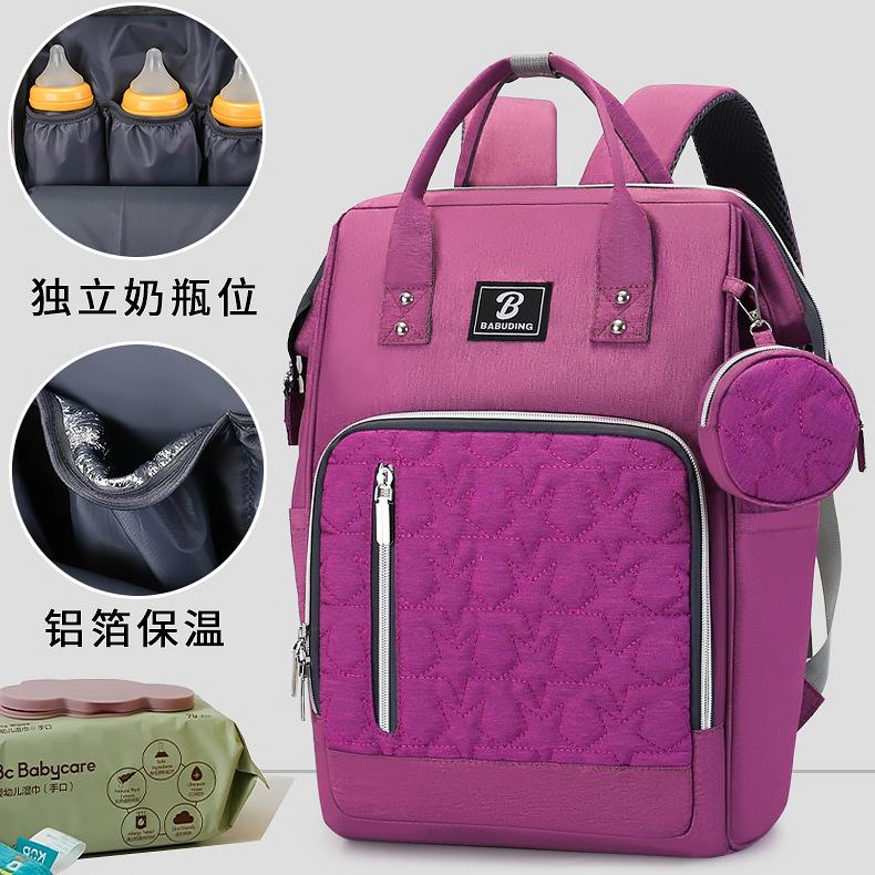 New style mommy bag with large capacity, featuring a patchwork design, contrasting colors, and a versatile, fashionable look. It’s a waterproof