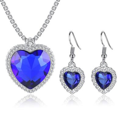 Ensemble de bijoux tendance pour femmes, composé d'un collier et de boucles d'oreilles en forme de cœur sertis de cristaux, couleur argent et cuivre.
