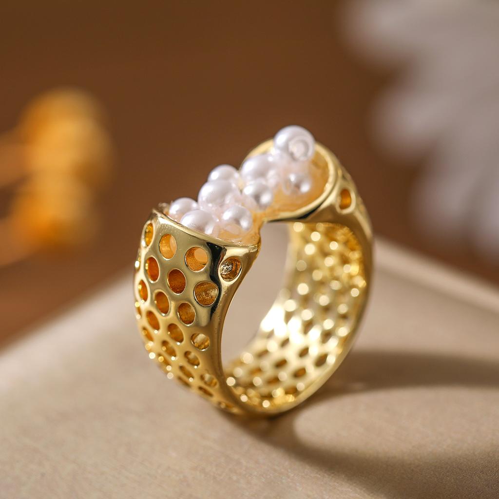 Creative and unique hollowed-out artificial imitation pearl ring made of copper. Suitable for women as a fashionable party gift.
