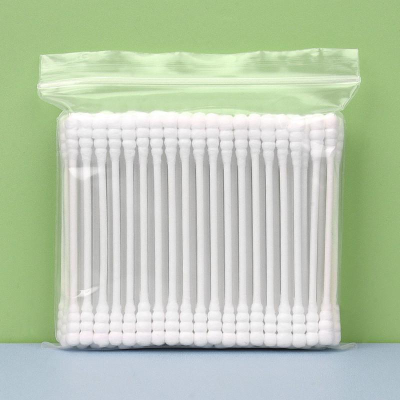 Pack of 100 double-ended, disposable cotton swabs with paper sticks for ear cleaning and makeup application.