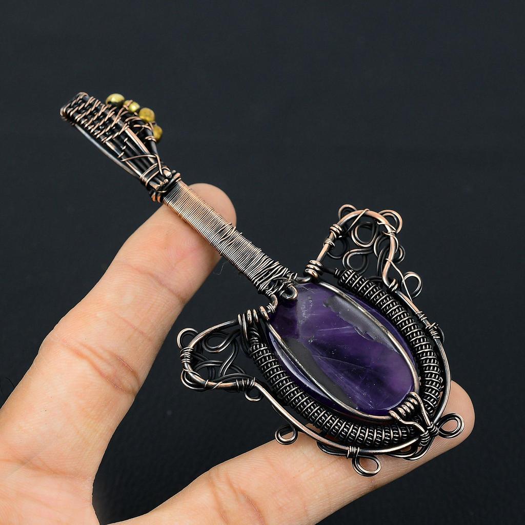Gitarrenförmiger Amethyst-Edelstein mit Kupferdraht umwickelt, handgefertigter Schmuckanhänger als Geschenk
