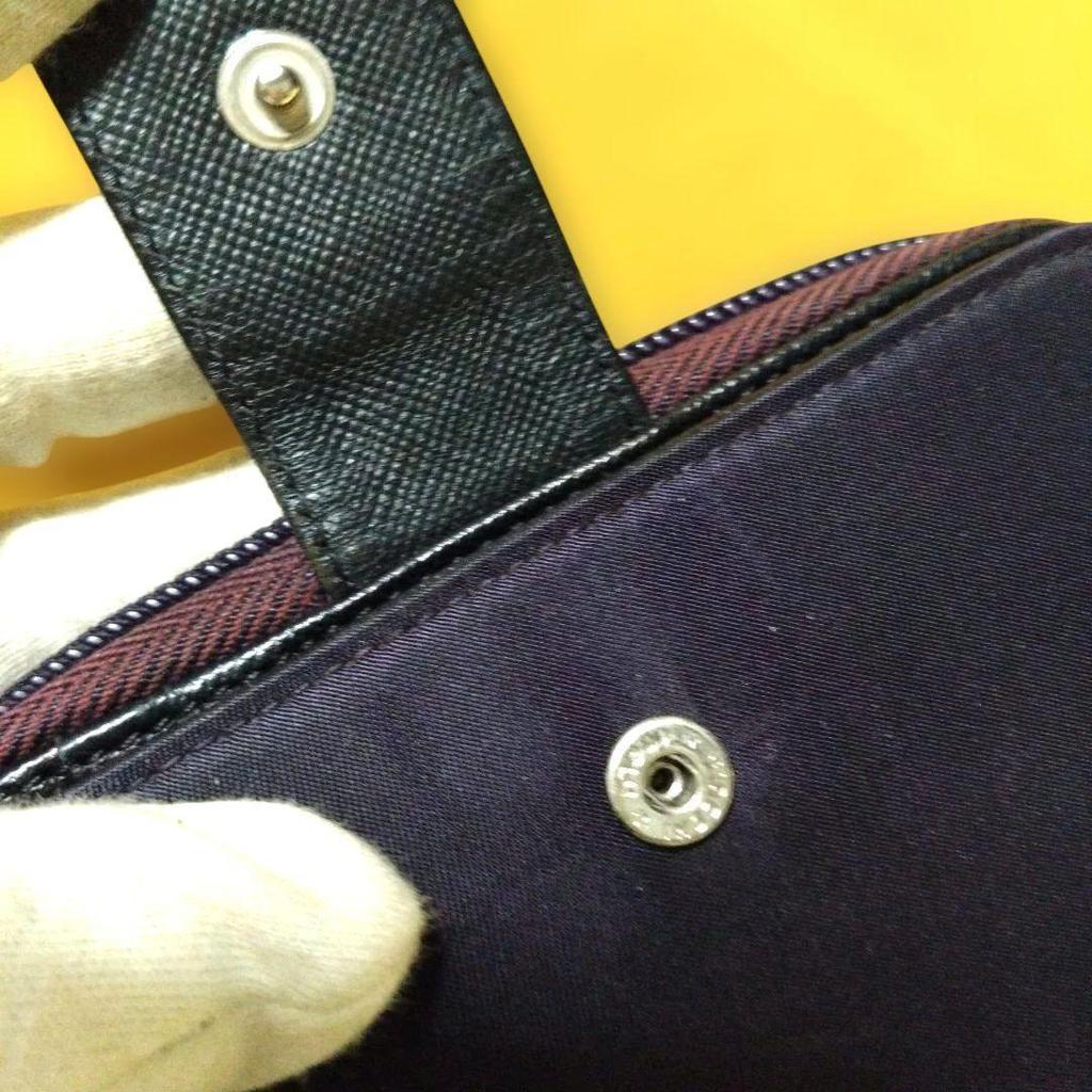 Used Excellent condition PRADA dry plum color bi-fold wallet with triangle logo plate and zipper