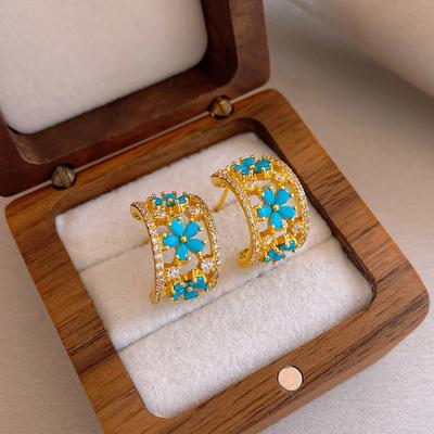Franse, moderne design oorbellen met blauwe zirkonia in de vorm van een bloem, verguld met 14 karaats goud, in C-vorm. Elegante accessoires voor dames, perfect voor dagelijks gebruik op het werk.
