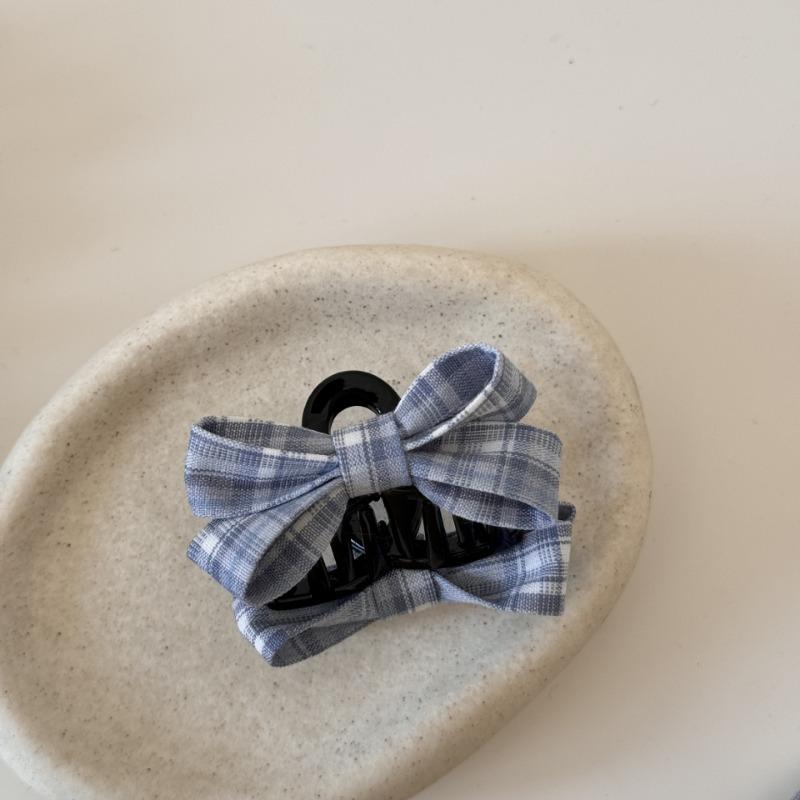 The Princess with The Checkered Bow Accessory Has A Chic Patterned Beak Hairpin At The Back of Her Head and A Hairclip.