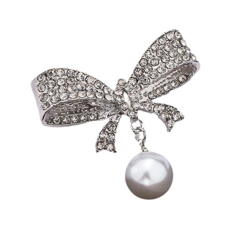 Módní brož s lukem: Kovové šperky s perlou a kamínkovou květinou