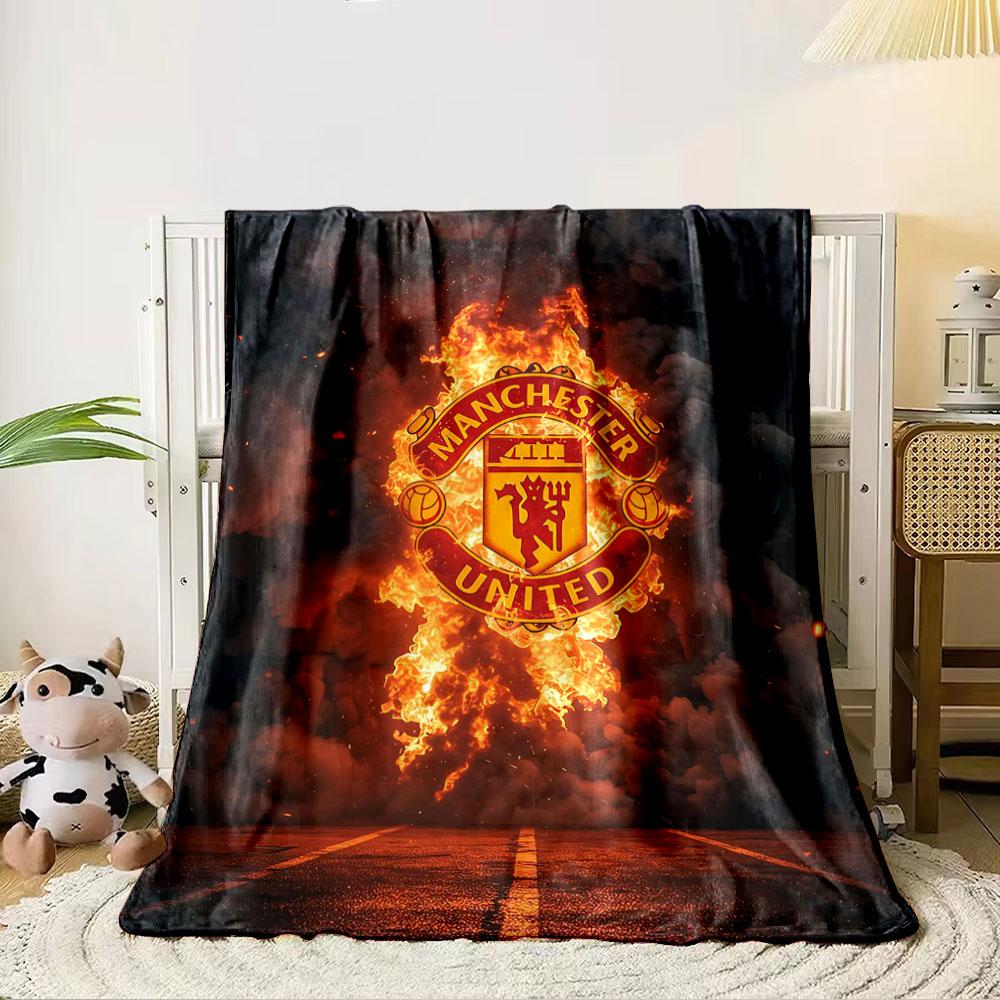 A Fiery Manchester United Logo Emerges Against Smoke and a Dark Background. for All Seasons Blanket Lunch Break Throw Gift