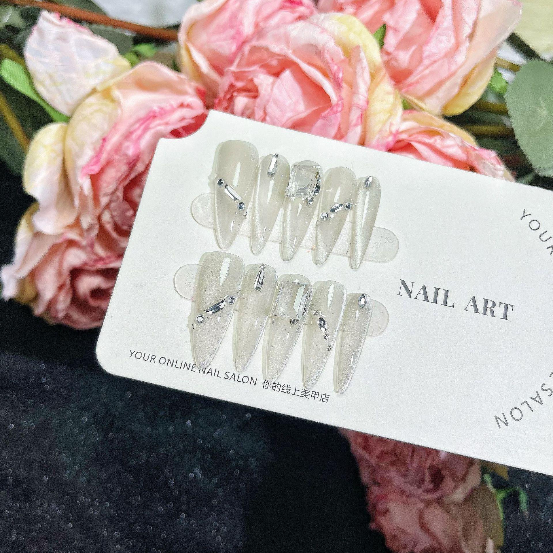 

Ручная работа, молочно-белые перламутровые накладные ногти с акцентами из страз и наклейками кошачий глаз Small