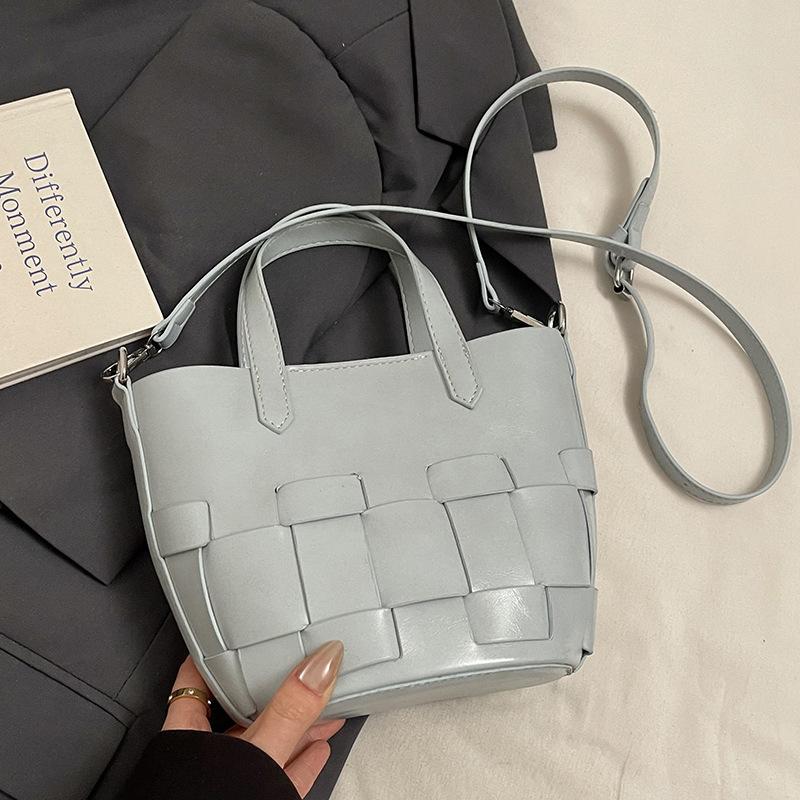 Spring and summer casual simple small fresh personalized woven design sense portable bucket bag fashionable versatile commuter messenger bag