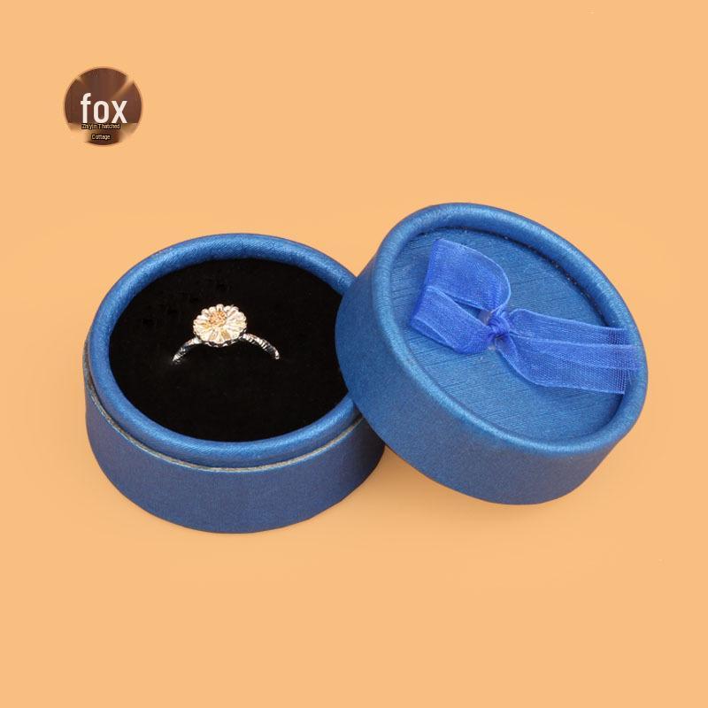 

Маленькая круглая шкатулка с бантиком для колец и серег