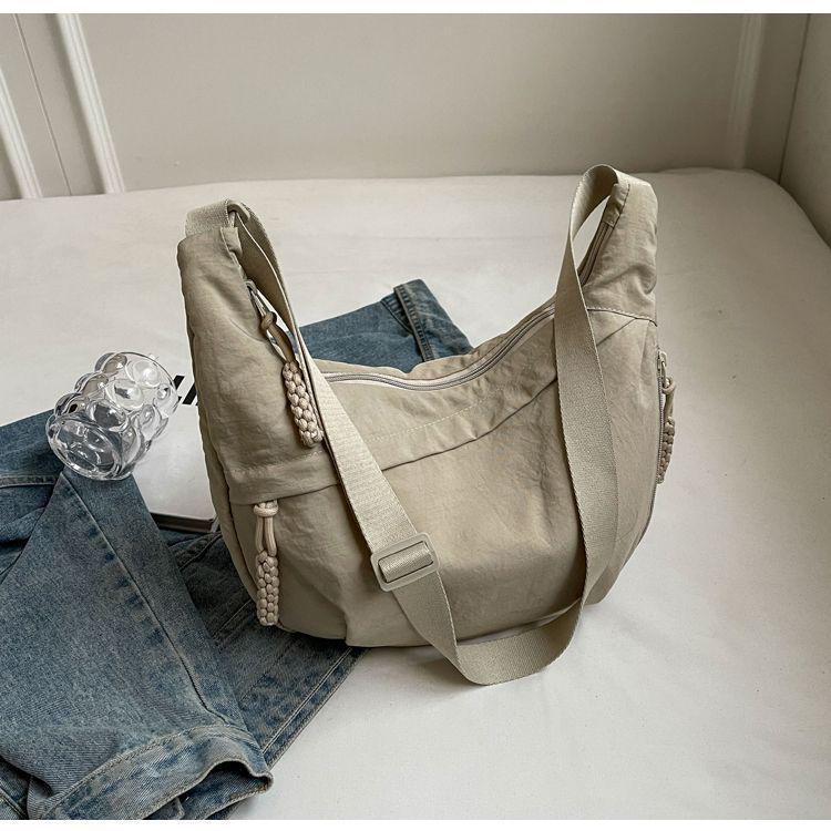 

2025 Новая женская сумка-пельмень большой вместимости через плечо - Легкая, повседневная, универсальная кроссбоди для модных и спортивных поездок грязно-белый