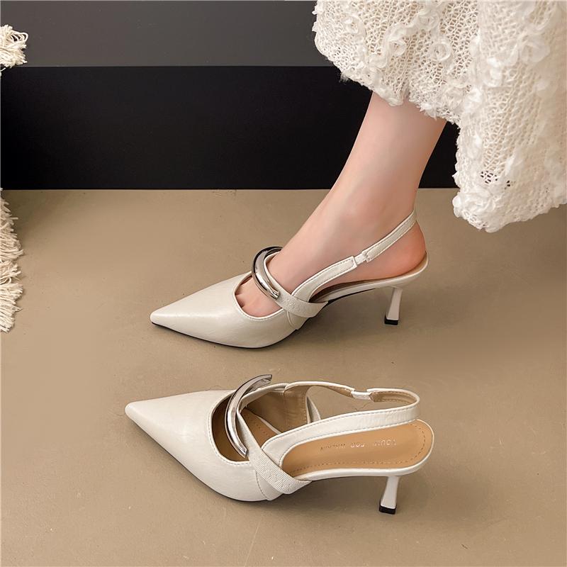 A Woman Wearing Half-slippers with An Inwardly Raised Metal Buckle Toe Cap and A Genuine Leather Pointed Toe on The Outside