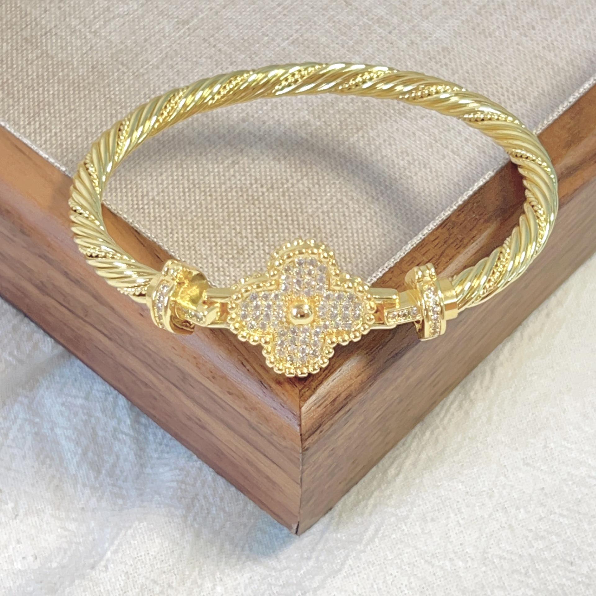 

Браслет из стальной проволоки с застежкой-подковой в виде четырехлистного клевера и микроинкрустацией из 18-каратного золота