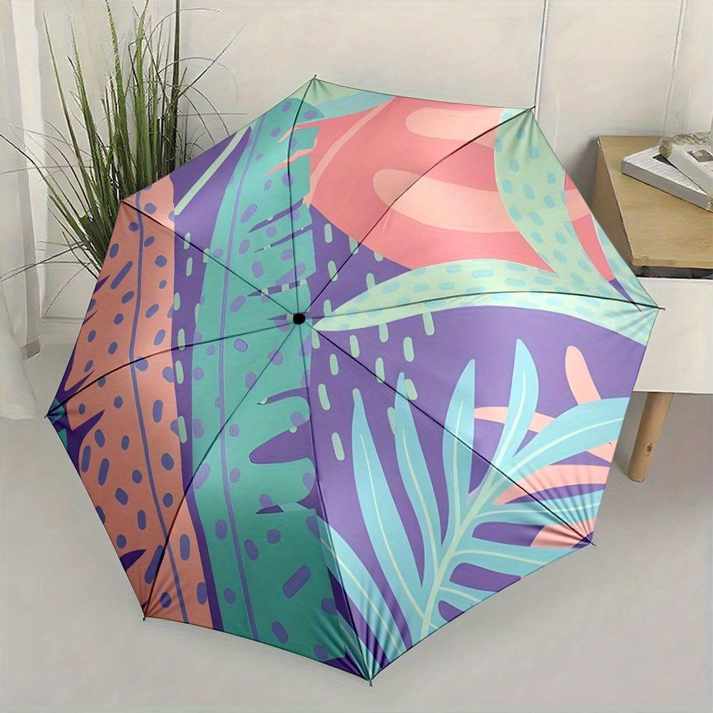 Folding Umbrella The umbrella features abstract tropical leaves and shapes in shades of purple, green, and peach. Fits Travel,