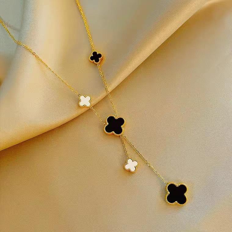 European & American Trendy Hollow Four-Leaf Clover Necklace with Black Shell Tassel Pendant.