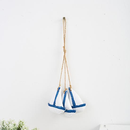 Rustikale Wanddekoration aus Holz im Küstenstil mit maritimen Strandmotiven, hängendem Ornament aus Juteseil, Seesternen, Meeresfischen und Segelboot – die perfekte Wanddekoration für Ihr Zimmer.
