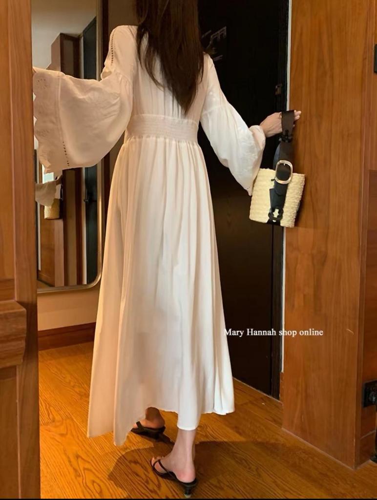 Robe blanche à manches longues et broderie ajourée pour les vacances à l'île ou à la plage