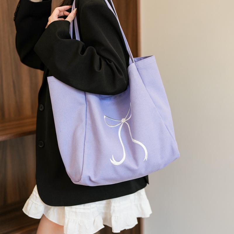 

Korean version canvas bag bag large capacity women s armpit bag 2025 new bow tote bag simple student class bag фиолетовый