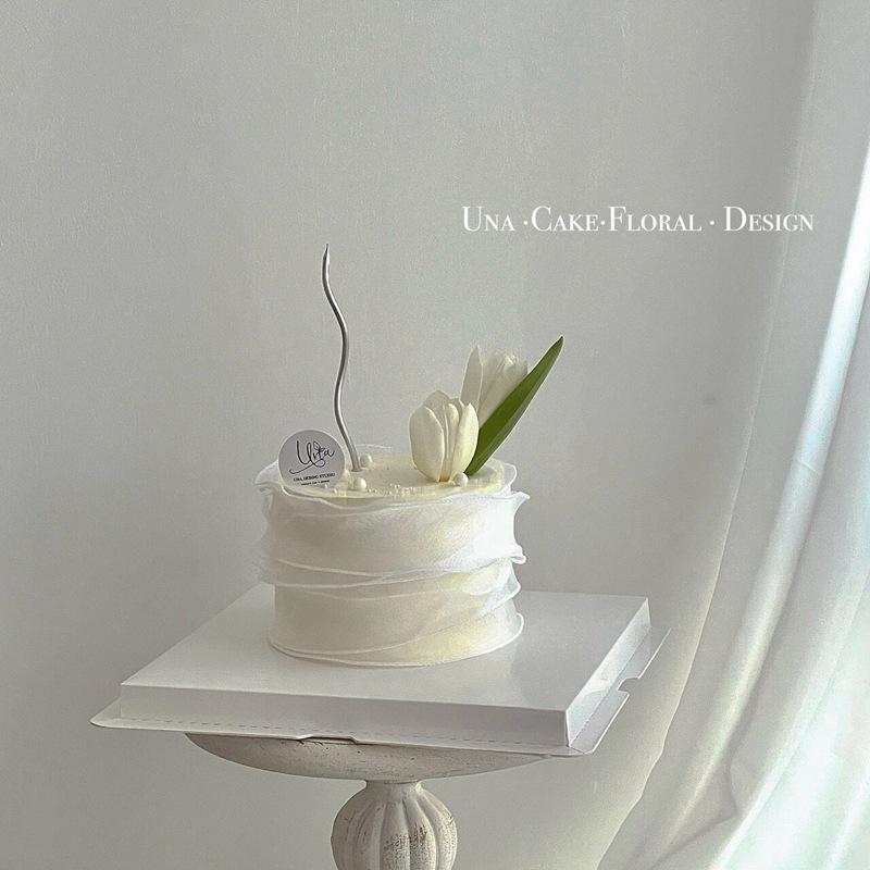 Minimalistischer Tulpen-Kuchenaufsatz mit frischen Blumen und Band für den Muttertag oder Geburtstag