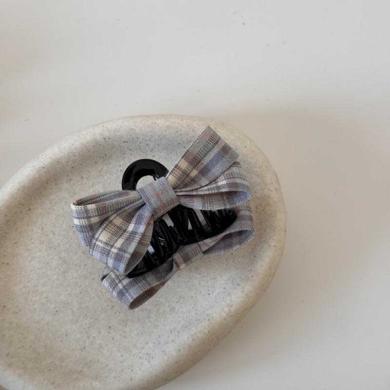 The Princess with The Checkered Bow Accessory Has A Chic Patterned Beak Hairpin At The Back of Her Head and A Hairclip.