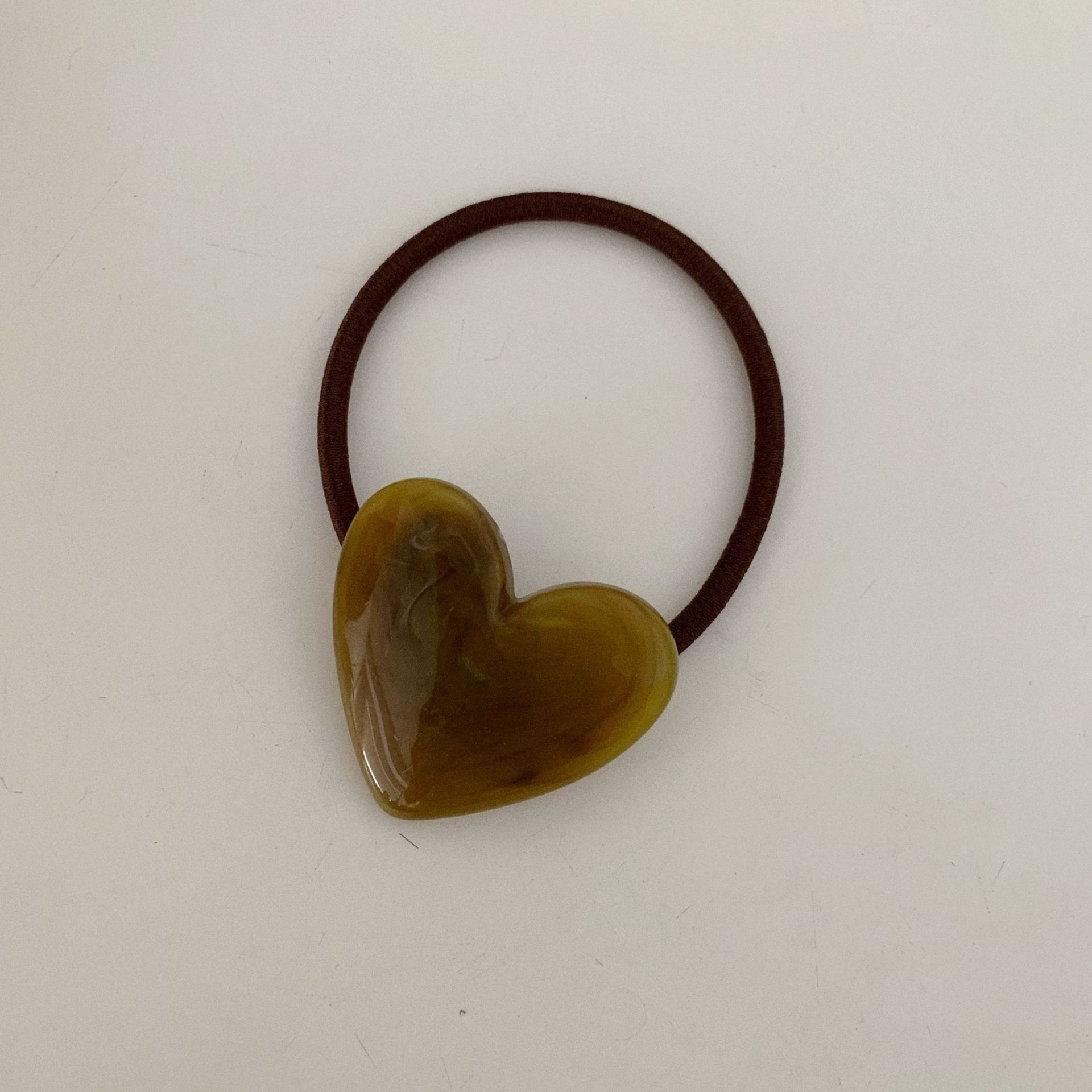 

Минималистичная и холодная резинка для волос в виде мраморного сердца, выполненная в технике туши темно-зеленого