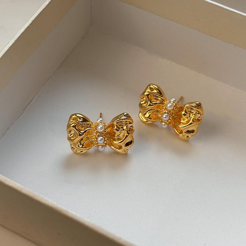 

Real gold electroplated pleated bow earrings women s European and American niche design pearl-set irregular stud earrings tide