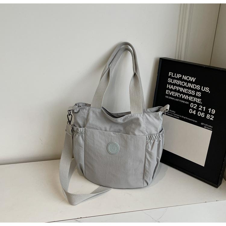 

2025 new simple shoulder bag casual versatile nylon premium handbag light commuter messenger bag women серый