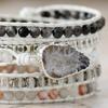 Handgefertigtes Perlenarmband mit 5 Strängen aus weißem Rindslederband und schwarzen und weißen Achat-Scheiben.