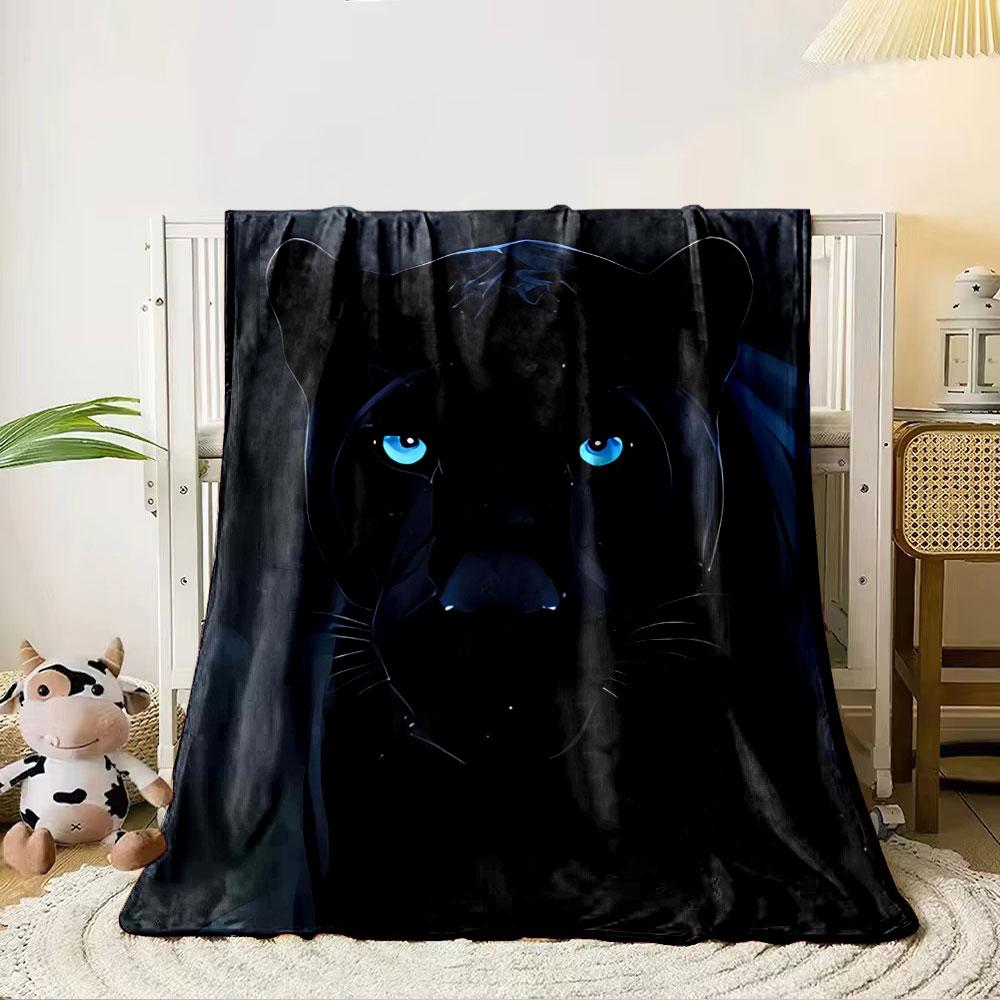 A sleek black panther with glowing blue eyes in a dark background. for all seasons blanket lunch break throw gift
