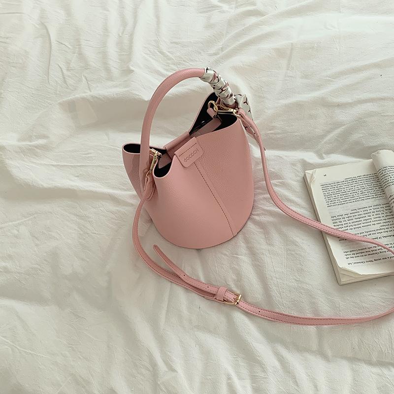 

Сумка - это модная и простая сумка-ведро с нишевым дизайном и сумка через плечо. розовый