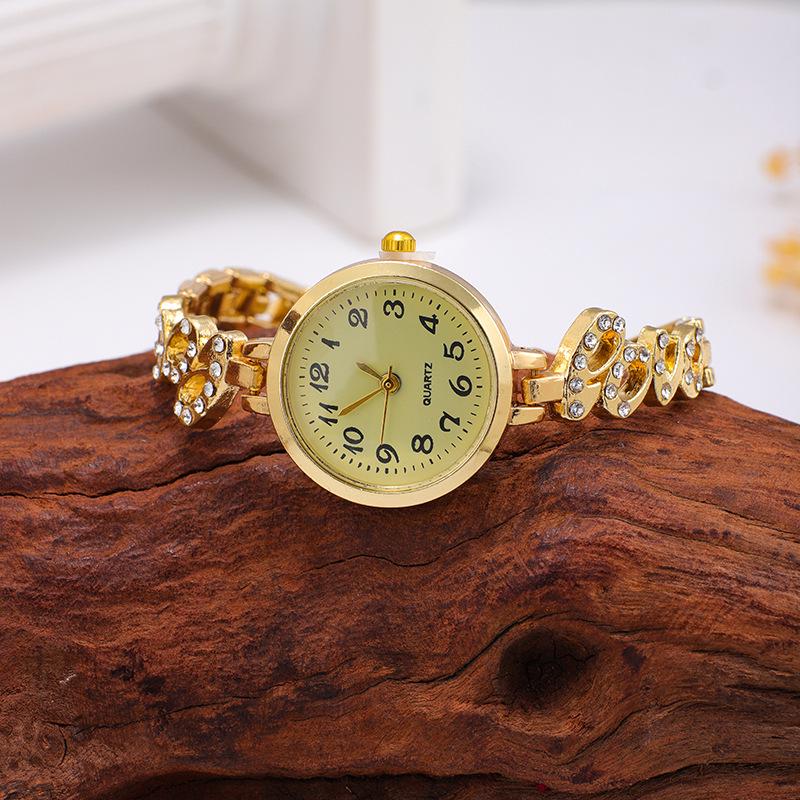 Nové dámské slitinové křemenné náramkové hodinky s náramkem s křídly z plných diamantů